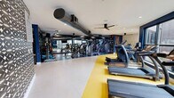 This 1,230 square foot fitness center, located at 701 Rahling Rd in Little Rock, AR, is a testament to modern gym design. The space is divided into distinct workout zones, each tailored for specific exercise types. The cardio area features a row of treadmills and ellipticals, positioned before large windows that flood the space with natural light. Weight training enthusiasts will appreciate the comprehensive selection of strength machines and free weights.

The facility's design incorporates a striking color scheme of navy blue, yellow, and white, creating a vibrant and energizing atmosphere. Exposed silver ductwork runs along the ceiling, adding an industrial chic element to the space. Recessed lighting and ceiling fans ensure comfort during workouts.

A separate studio space, distinguished by its blue walls, houses exercise balls and yoga mats, ideal for stretching or group classes. Motivational artwork adorns the walls, inspiring members during their fitness routines. The gym's layout promotes easy navigation between equipment, with ample space for comfortable movement.

High-end finishes, including sleek flooring and glass partitions, contribute to the gym's upscale feel. The thoughtful design extends to the entrance area, featuring patterned wallpaper and modern lighting fixtures, setting a sophisticated tone from the moment members enter the facility.