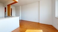 Located at 1190 Mission Street in San Francisco's SoMa neighborhood, this single-floor unit offers a well-organized and functional layout with a clean, modern aesthetic throughout. Warm-toned hardwood flooring extends across the main living areas and bedroom, lending a cohesive and inviting feel to the space.

The galley-style kitchen is efficiently designed, featuring white cabinetry with sleek silver hardware, dark countertops, a stainless steel sink, and white appliances including a stove and dishwasher. Under-cabinet lighting enhances both functionality and ambiance, while the layout flows directly into the open living area.

The living space is bright and open, with crisp white walls and abundant natural light creating an airy atmosphere. The bedroom benefits from large windows that frame views of the surrounding cityscape, allowing sunlight to fill the room throughout the day. A vertical panel radiator provides heating, and warm-toned wood accents add character to the space.

The bathroom is clean and well-appointed, featuring white tile walls and flooring, a full soaking tub with an overhead shower, chrome fixtures, and built-in open shelving for storage. The overall design of the unit emphasizes simplicity and practicality, making it a functional urban residence in the heart of San Francisco.