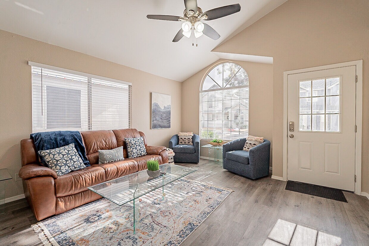 Living room with large 4k Smart TV on wall. Both sides of sofa recline and blue chairs pivot. - 235 N 22nd Pl