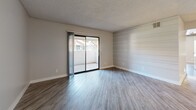 Located at 1975 E University Dr in Tempe, Arizona, this 2-bedroom, 2-bathroom residence offers a thoughtfully designed single-floor layout with contemporary updates throughout. The combined kitchen and living room serves as the heart of the home, featuring light wood-look flooring, a textured ceiling, and a distinctive horizontal shiplap accent wall that adds character to the space. A sliding glass door floods the living area with natural light and opens to a private patio, providing a seamless indoor-outdoor connection. The galley-style kitchen is well-appointed with two-tone cabinetry — white upper cabinets paired with gray lower cabinets — complemented by white quartz countertops, a stainless steel sink, and a full suite of stainless steel appliances including a refrigerator, range, and built-in microwave. Both bedrooms are generously sized, each equipped with a ceiling fan and natural light from multiple windows. The spacious primary bedroom offers a comfortable and private retreat. The two bathrooms are finished with matching gray cabinetry, white quartz vanity tops, and wood-look flooring, with one featuring a full soaking tub and shower combination. A dedicated hallway and closet complete the practical layout of this well-maintained Tempe residence.