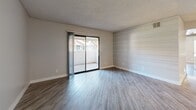 Located at 1975 E University Dr in Tempe, Arizona, this 2-bedroom, 2-bathroom unit offers a well-designed, single-level layout with contemporary updates throughout. The open living area features wood-style flooring in a warm gray tone, a textured ceiling, and a distinctive shiplap accent wall that adds character to the space. A sliding glass door floods the living room with natural light and opens directly onto a private patio, providing a seamless indoor-outdoor connection.

The galley-style kitchen is thoughtfully appointed with two-tone cabinetry — white uppers and gray lowers — paired with white quartz countertops and stainless steel appliances, including a refrigerator, range, and microwave. A pass-through window connects the kitchen to the living area, enhancing the open feel.

Both bedrooms are generously proportioned, with the primary bedroom offering ample space, wood-style flooring, a ceiling fan, and dual windows that invite natural light. The second bedroom also features a ceiling fan and a window with an outdoor view. Each bathroom is finished with gray cabinetry, quartz countertops, and wood-style flooring. The full bathroom includes a tub-shower combination. A hallway and dedicated closet space round out the functional layout of this well-maintained Tempe residence.