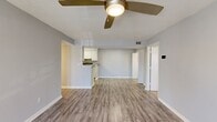 Located at 902 Baywood Cir in Morrow, GA, this single-story home offers four bedrooms and two bathrooms across a well-organized floor plan. The open-concept living room and kitchen area form the heart of the home, featuring light gray walls, durable luxury vinyl plank flooring, and a ceiling fan with integrated lighting. Natural light flows in through French doors in the living area, adding brightness and an airy feel. The kitchen is equipped with white cabinetry, black appliances including a refrigerator and electric range, a peninsula counter, and continues the same LVP flooring for a cohesive look. The four bedrooms offer comfortable accommodations, with several rooms featuring plush carpeting, individual ceiling fans or light fixtures, and windows that invite natural light. The spacious primary bedroom includes access to a dedicated closet outfitted with wire shelving for practical organization. Both bathrooms are finished with light wood-tone LVP flooring, white vanities with ample under-sink storage, and clean, simple fixtures. A hallway connects the living spaces to the private quarters, and two closets provide additional storage throughout. Textured ceilings and neutral-toned walls carry consistently through the home, creating a clean and move-in ready environment.