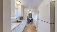 This thoughtfully designed one-bedroom, one-bathroom residence in Walnut Creek, CA offers a functional and comfortable single-floor layout. The galley-style kitchen features white shaker cabinetry, light wood flooring, a stainless steel sink, and a full suite of appliances including a dishwasher and refrigerator, opening directly into a dedicated dining area equipped with a ceiling fan and sliding door access to the exterior.

The living room is carpeted and generously proportioned, bathed in natural light from large sliding glass doors that lead to a private patio with outdoor views. A ceiling fan adds to the comfort of this open, airy space, which flows seamlessly from the dining area.

The bedroom offers a cozy, well-lit retreat with warm tones, soft carpeting, and ample wall space. The full bathroom includes a wood-finish vanity with a white countertop, a tub/shower combination, and light wood flooring. A hallway connects the primary areas of the unit, providing a clean, organized flow throughout. The overall ambiance is bright, neutral, and move-in ready.