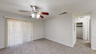 Located at 220 Oakley Dr in Columbus, Georgia, this single-story home offers three bedrooms, one bathroom, a kitchen, and two hallways within a compact but efficiently arranged floor plan. Crown molding is a consistent architectural detail present throughout the home, lending a clean, finished appearance to each room.

The bedrooms are carpeted and feature ceiling fans with light fixtures, neutral-toned walls, and white baseboards. The primary bedroom includes a sliding glass door covered by vertical blinds, allowing natural light to filter in. Additional bedrooms feature horizontal blinds over windows that provide outdoor views of surrounding greenery. One bedroom displays painted brick walls, adding a subtle textural element, while another features chair-rail wainscoting detail.

The kitchen is equipped with light wood cabinetry, a stainless steel sink, a black refrigerator, and hardwood-style vinyl flooring, offering a practical cooking and dining space. A dedicated closet with a full-width hanging rod provides storage within the home.

The single bathroom includes a bathtub and shower combination with sliding glass doors set against textured walls. Two hallways connect the rooms, contributing to an organized and navigable layout throughout the home.