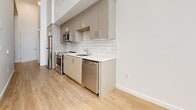 This contemporary 420 square foot studio apartment in Carson, CA, offers a well-designed living space on a single floor. The interior features a modern aesthetic with crisp white walls and warm hardwood flooring throughout, creating a cohesive and inviting atmosphere.

The kitchen is a standout feature, boasting sleek light-colored cabinetry that extends to the ceiling, maximizing storage. Stainless steel appliances, including a refrigerator, stove, and dishwasher, complement the clean design. A subway tile backsplash adds a classic touch, while the light-colored countertops enhance the sense of space.

The living area is bathed in natural light thanks to large windows, creating a bright and airy ambiance. The open floor plan allows for flexible furniture arrangements, making the most of the compact square footage. High ceilings contribute to a sense of spaciousness.

Clever storage solutions, such as built-in closets with louvered doors, help maintain a clutter-free environment. The apartment's layout efficiently incorporates all necessary living spaces while maintaining a feeling of openness and flow. This studio is ideal for those seeking a modern, low-maintenance living space in an urban setting.