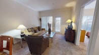This single-floor residence offers a thoughtfully designed layout that balances comfort and functionality. The living area serves as the heart of the space, featuring plush carpeting, elegant crown molding, and generous natural light streaming through vertical blinds and a glass-paned exterior door that opens to the outdoors. The room provides ample space for seating and entertaining, with a warm, inviting ambiance.

The kitchen is outfitted with light wood cabinetry offering abundant storage, white appliances including a refrigerator, electric range, microwave, and dishwasher, and a double sink. Wood-look flooring adds a clean, practical touch to the space.

The bedroom is a serene retreat, featuring soft carpeting, a ceiling fan, and a large window dressed with vertical blinds that allow natural light while maintaining privacy. The room comfortably accommodates a full-sized bed and additional furnishings.

The bathroom is finished with wood-look flooring, a single-sink vanity with ample counter space, a large mirror with overhead lighting, and convenient towel storage. Adjacent to the bathroom is a generously sized walk-in closet equipped with a built-in shelving and hanging system, offering excellent organization potential. Overall, the space presents a cohesive and comfortable living environment.