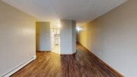 Located at 725 42nd St S in Fargo, North Dakota, this single-floor unit offers a practical and well-organized layout suited for comfortable everyday living. The kitchen is designed for functionality, featuring white cabinetry with wood-tone trim, ample upper and lower storage, light countertops, tile flooring, and a full suite of appliances including a refrigerator, electric range, dishwasher, and a stainless steel sink. An open layout connects the kitchen to the main living area, which is finished with rich, dark hardwood-style flooring that extends throughout much of the unit. The living area is bright and airy, highlighted by a sliding glass door that opens to a private balcony with outdoor views — a standout feature that brings in generous natural light. Two bedrooms provide comfortable, quiet retreats, each featuring the same dark hardwood-style flooring, neutral-toned walls, large windows with vertical blinds, and baseboard heating for year-round comfort. The full bathroom is clean and straightforward, appointed with tile flooring, a vanity with under-sink storage, a wall-mounted mirror, and a tub/shower combination. Textured ceilings are consistent throughout the space, adding a classic residential character to this well-maintained Fargo unit.