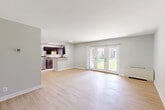 Located at 7400 Parkwood Ct, Unit 102 in Falls Church, Virginia, this two-bedroom, one-bathroom residence offers a well-organized single-floor layout with a clean, modern aesthetic throughout. Light wood-style flooring runs continuously through the living areas, bedrooms, and hallway, lending warmth and visual cohesion to the space.

The living room is a bright, open area anchored by a set of French doors that flood the room with natural light and open to a lush green outdoor area — a standout feature of this unit. A wall-mounted climate unit sits conveniently nearby.

The kitchen has been thoughtfully updated with dark espresso shaker cabinets, granite-style countertops, stainless steel appliances including a dishwasher, range, and refrigerator, and a window that brings in additional natural light.

Both bedrooms are well-proportioned, with light-toned walls, ceiling fans, and windows overlooking the exterior. The primary bedroom offers generous space and includes a closet with bi-fold doors. The second bedroom provides a comfortable, versatile layout.

The bathroom features a full tub-shower combination with white subway tile surround and a mirrored medicine cabinet. A dedicated hallway and closet round out the functional layout of this well-maintained Falls Church residence.