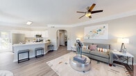 Located at 15335 Park Row Dr in Houston, TX, this well-appointed single-story home offers 2 bedrooms and 2 bathrooms within a thoughtfully designed open-concept floor plan. Wood-style flooring flows throughout the living areas, complemented by crown molding and neutral tones that create a clean, cohesive aesthetic.

The living room is bright and welcoming, featuring a ceiling fan, natural light from multiple windows, and a seamless connection to both the dining area and kitchen. The dining space is surrounded by large windows that flood the area with natural light, making it an ideal spot for everyday meals. The kitchen is outfitted with white shaker cabinetry, stainless steel appliances including a refrigerator, range, and microwave, and a breakfast bar that enhances functionality and flow.

The primary bedroom is generously sized, highlighted by crown molding, a ceiling fan, and a calming accent wall. It connects to a dedicated closet with built-in wire shelving. The bathrooms are finished with white cabinetry and include a tub-shower combination. An in-unit laundry area with washer and dryer connections adds everyday convenience. Two hallways and two closets round out a layout that balances practicality with comfortable living.