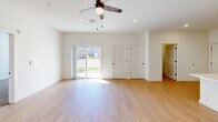 Located in Maiden, NC, this single-story 1-bedroom, 1-bathroom home offers a thoughtfully designed layout with modern finishes throughout. The open-concept kitchen and living area serves as the heart of the home, featuring light hardwood-style flooring, recessed lighting, and a ceiling fan. The kitchen is equipped with dark espresso cabinetry, stainless steel appliances including a range, microwave, and refrigerator, and a light quartz countertop peninsula with pendant lighting and an integrated sink — ideal for both cooking and casual dining. The living area extends to a sliding glass door that invites natural light and provides outdoor access. The spacious bedroom features plush carpeting, a ceiling fan, dual windows for natural light, and a generous double-door closet for ample storage. The full bathroom is finished with dark wood vanity cabinetry, quartz countertops, light hardwood-style flooring, and a full tub-shower combo with sleek sliding glass doors. A dedicated laundry room houses a full-size washer and dryer with overhead wire shelving for added convenience. Clean white walls and consistent flooring throughout give the home a fresh, cohesive aesthetic.