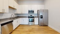 Located at 260 Pidgeon Bay Rd in Summerville, SC, this single-floor home offers a clean, modern design with a bright and functional layout. The open-concept living and kitchen area is anchored by warm hardwood-style flooring and recessed lighting, creating a welcoming, airy atmosphere. The kitchen is well-appointed with white shaker-style cabinetry, dark countertops, and a full suite of stainless steel appliances including a range, over-the-range microwave, French door refrigerator with ice and water dispenser, and a dishwasher. A dedicated in-unit laundry area houses a full-size washer and dryer with overhead wire shelving for added storage convenience. The bedrooms feature plush carpeting and multiple windows that invite generous natural light and offer views of the surrounding neighborhood. Ceiling fans add comfort to both the living area and bedrooms. Two bathrooms are finished with light hardwood-style flooring and white cabinetry; one includes a tub/shower combination, while the other serves as a half bath. Throughout the home, a consistent neutral color palette of soft whites and grays lends a clean, move-in-ready feel that suits a variety of design preferences.