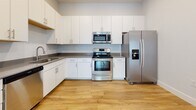 Located at 260 Pidgeon Bay Rd in Summerville, SC, this single-floor home offers a clean, modern design with a bright and functional layout. The open-concept living and kitchen area is anchored by warm hardwood-style flooring and recessed lighting, creating a welcoming, airy atmosphere. The kitchen is well-appointed with white shaker-style cabinetry, dark countertops, and a full suite of stainless steel appliances including a range, over-the-range microwave, French door refrigerator with ice and water dispenser, and a dishwasher. A dedicated in-unit laundry area houses a full-size washer and dryer with overhead wire shelving for added storage convenience. The bedrooms feature plush carpeting and multiple windows that invite generous natural light and offer views of the surrounding neighborhood. Ceiling fans add comfort to both the living area and bedrooms. Two bathrooms are finished with light hardwood-style flooring and white cabinetry; one includes a tub/shower combination, while the other serves as a half bath. Throughout the home, a consistent neutral color palette of soft whites and grays lends a clean, move-in-ready feel that suits a variety of design preferences.