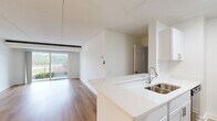 Located at 100 S Van Dorn St in Alexandria, Virginia, this one-bedroom, one-bathroom residence offers a well-designed layout with modern finishes throughout. The open-concept kitchen and living area serves as the heart of the home, featuring light hardwood-style flooring, crisp white walls, and a seamless flow that maximizes the sense of space. The kitchen is equipped with white shaker cabinetry, quartz countertops, a double-basin stainless steel sink, and stainless steel appliances including a gas range, microwave, and refrigerator. A peninsula counter provides additional workspace and a natural division between the kitchen and living area. The living room opens directly onto a private balcony through a full-width sliding glass door, filling the space with natural light and providing outdoor views of surrounding greenery. The spacious primary bedroom includes multiple closets with sliding doors and a window with natural light. The bathroom is appointed with a quartz vanity, white shaker cabinetry with brushed nickel hardware, a large mirror, and a separate shower/tub enclosure. Additional highlights include four closets for ample storage, a dedicated laundry area, and consistent hardwood-style flooring throughout the unit.