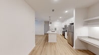 Located at 13030 Perry Road in Houston, TX, this well-appointed 2-bedroom, 2-bathroom single-story home offers a clean, modern aesthetic with thoughtful finishes throughout. The open-concept layout centers around a stunning kitchen, which serves as the heart of the home. White shaker cabinetry, a herringbone-patterned tile backsplash, granite countertops, and stainless steel appliances—including a range, microwave, and refrigerator—are complemented by a spacious center island with a built-in sink and pendant lighting above. A convenient built-in desk area with granite surface provides additional utility just off the kitchen. Light wood-style flooring runs throughout the entire home, lending a bright and cohesive feel. The living areas feature ceiling fans and large windows with blinds that invite natural light. The primary bedroom offers a comfortable footprint with a walk-in closet equipped with wire shelving for ample storage. Both bathrooms are finished with granite vanity tops and white cabinetry; one bathroom features a tub and shower combination with elegant marble-style tile surround. An in-unit laundry area with washer and dryer hookups adds everyday convenience, rounding out this efficiently designed and attractively finished home.
