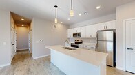 Located at 226 Bucknoll Road in Manheim, PA, this single-floor residence offers a thoughtfully designed layout with 2 bedrooms and 2 bathrooms across a generously sized floor plan. The contemporary aesthetic is carried throughout with neutral tones, light-toned luxury vinyl plank flooring in the main living areas, and an abundance of natural light.

The kitchen serves as a central highlight, featuring a large island with a double-basin sink, crisp white shaker cabinetry, light quartz countertops, and a full suite of stainless steel appliances including a range, microwave, and refrigerator. Stylish pendant lighting accents the island, creating a clean and functional space. The kitchen flows seamlessly into the bright living room, which is outfitted with sliding glass doors leading to a private balcony overlooking the surrounding community and open skies.

The primary bedroom is a comfortable retreat with soft carpet flooring, generous closet space, and access to a dedicated bathroom. The second bedroom also features carpet and bright windows with exterior views. Both bathrooms are finished with white shaker vanities, light countertops, and wood-look flooring. The entrance and hallway connect all areas efficiently, completing this well-organized and modern single-level home.