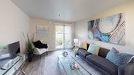 Located at 11239 SE 260th St in Kent, WA, this single-floor unit offers a thoughtfully designed layout with modern finishes throughout. Wood-style flooring flows seamlessly across the living areas, tying together a cohesive and contemporary aesthetic.

The kitchen is efficiently designed with white upper cabinetry, dark lower cabinets, stainless steel appliances, and a built-in breakfast bar with seating for two — ideal for casual dining. It opens toward the entryway, contributing to a welcoming sense of flow upon arrival.

The living room is bright and inviting, benefiting from natural light streaming through a large sliding glass door that leads to an outdoor patio. The space comfortably accommodates a seating area and offers an open, airy atmosphere with a textured ceiling and neutral wall tones.

The bedroom is well-proportioned, featuring wood-style flooring, soft neutral walls, and a window with outdoor views that fills the room with natural light. Stylish curtains and decorative accents contribute to a calm, restful ambiance.

The bathroom is clean and modern, showcasing a dark wood vanity with a white countertop and integrated sink, a large frameless mirror with contemporary lighting above, and a full shower-tub combination. The overall design of this unit balances functionality with a polished, move-in-ready presentation.