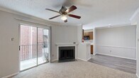 Located at 3003 Windchase Blvd in Houston, TX, this two-bedroom, one-bathroom unit offers a practical and comfortable single-floor layout. The combined kitchen and living room area forms the heart of the home, where a cozy fireplace with a classic white mantle and dark tile surround anchors the living space, complemented by crown molding, a ceiling fan, and plush carpeting. The kitchen features warm wood cabinetry, speckled granite-style countertops, a stainless steel sink, and light wood-look vinyl flooring that extends through the main corridor — a clean, functional galley-style layout with ample storage and a window that brings in natural light.

Both bedrooms are carpeted and equipped with ceiling fans. The primary bedroom is generously sized with a sliding glass door opening to a private balcony, providing outdoor views. The second bedroom includes a window and access to a louvered-door closet. A dedicated walk-in closet with wire shelving offers additional storage. The full bathroom presents a tub-shower combo with tiled surround, a wood-vanity with granite-style countertop, and wood-look flooring, maintaining a cohesive, neutral aesthetic throughout the unit.