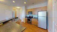 Located at 13200 York Rd in Charlotte, NC, this single-floor unit offers a well-designed layout that balances comfort and functionality. The kitchen is outfitted with warm wood-tone cabinetry, dark granite-style countertops, stainless steel appliances including a range, built-in microwave, and refrigerator, complemented by hardwood-style flooring that extends into the entryway. A peninsula counter separates the kitchen from the open living area, which features plush carpeting and access to a patio door that brings in natural light.

The bedrooms are carpeted and generously sized, each featuring large windows with exterior views of the surrounding neighborhood and lush greenery. Closet space is provided, including a walk-in style closet with built-in rods for organized storage.

Two full bathrooms serve the unit. One features a glass-enclosed walk-in shower, white cabinetry, and a dark granite-style vanity top with a single basin sink and well-lit mirror. The second bathroom includes a full soaking tub with shower combination, matching white cabinetry, and consistent hardwood-style flooring. Throughout the unit, neutral tones and clean finishes create a bright, move-in-ready environment.