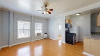 Located at 117 S Isabel St in Glendale, CA, this one-bedroom, one-bathroom unit offers a efficiently organized single-floor layout. Throughout the space, warm hardwood-style flooring and light gray walls create a cohesive, neutral aesthetic, while white crown molding adds a refined architectural detail to each room.

The living area is the largest space in the unit, featuring a ceiling fan with integrated lighting and windows that allow natural light to filter in. The kitchen is positioned adjacent to the living area and includes light wood cabinetry, a granite-style countertop, an undermount sink, and black appliances including a gas range and refrigerator. The layout makes practical use of the available space.

The bedroom is a cozy, well-defined room with a window fitted with blinds and a mirrored sliding closet that enhances the sense of space. Crown molding continues throughout, maintaining design consistency. The bathroom features tile flooring, fully tiled walls, and a bathtub-shower combination accented with a decorative tile border. Overall, the unit presents a clean, functional living environment suited for single occupancy.