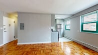 Located at 12 Marshall St in Irvington, NJ, this 2-bedroom, 1-bathroom unit offers a well-organized single-floor layout. Throughout the space, warm-toned parquet wood flooring creates a cohesive and classic aesthetic, complemented by neutral grey walls and clean white trim.

The combined living room and kitchen area forms the heart of the unit. The living room offers generous open space with natural light filtering through green-trimmed windows, while the adjacent kitchen is efficiently designed with modern grey cabinetry, stainless steel appliances including a gas range, microwave, and full-size refrigerator, and bright white floors. A baseboard heating system runs along the perimeter, ensuring year-round comfort.

The primary bedroom is a well-proportioned room featuring a large window with exterior views, providing ample natural light. The second bedroom offers a similarly comfortable and versatile space. A hallway connects the rooms and provides access to the full bathroom, which is elegantly finished with marble-style wall tile, a soaking tub, a glass sliding shower door, and a clean white sink vanity. The unit also includes an electrical panel conveniently located within the living area.