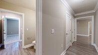 Located at 3491 SW 42nd St in Ocala, Florida, this single-story home offers a well-designed layout with a cohesive neutral color palette of warm taupe and crisp white trim throughout. The galley-style kitchen is a standout feature, showcasing rich dark wood cabinetry, granite countertops, a white subway tile backsplash, stainless steel appliances, and wood-look luxury vinyl flooring — all contributing to a clean, modern aesthetic. The open living area is finished with the same wood-look flooring and is brightened by a ceiling fan with light fixture and windows dressed with blinds, allowing natural light to fill the space. Bedrooms are carpeted for comfort and include windows that offer views of the surrounding greenery. A generously sized walk-in closet is outfitted with multi-tiered wire shelving systems, providing ample storage. The hallway is trimmed with crown molding and white panel doors, adding a polished touch. Bathrooms feature dark wood vanities with granite countertops, large mirrors, and a tub-shower combination. Throughout the home, consistent finishes and thoughtful details create a functional and welcoming living environment.