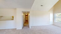Located at 700 Stonehouse Dr in Napa, CA, this single-story, 3-bedroom, 2-bathroom home offers a practical and comfortable layout. The living room is a standout space, featuring striking vaulted ceilings that create an open, airy atmosphere, plush carpeting, a ceiling fan, and a front entry with wood-look flooring. Natural light filters in through windows, offering views of the surrounding neighborhood.

The spacious primary bedroom continues the vaulted ceiling design, with soft carpeting and ample room for furnishings. A wide sliding-door closet provides generous storage. The remaining two bedrooms also feature carpet and windows that bring in natural light.

Both bathrooms are finished with wood-look flooring, light wood cabinetry, and well-lit vanities featuring large mirrors and medicine cabinets. A convenient stacked washer and dryer unit is tucked neatly into a dedicated alcove.

The kitchen, visible in the floor plan, connects efficiently to the living areas and includes light wood cabinetry. A hallway links the bedrooms and bathrooms, keeping the layout organized and easy to navigate. The home's neutral color palette and clean finishes provide a versatile canvas throughout.