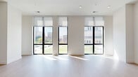 Located in the heart of Indianapolis on N Pennsylvania Street, this modern 2-bedroom, 2-bathroom residence offers a thoughtfully designed open-concept layout with high-end finishes throughout. The expansive living and kitchen area is bathed in natural light through large floor-to-ceiling windows framed in bold black, offering sweeping views of the downtown Indianapolis skyline and surrounding greenery. Light hardwood-style flooring runs throughout the main living areas, enhancing the bright and airy ambiance. The sleek kitchen features a generous island with an undermount sink, crisp white countertops, dark wood cabinetry, stainless steel appliances including a French door refrigerator, and a striking pendant light fixture overhead. A clean, white hallway connects the living spaces to the private quarters, lined with multiple closets for ample storage. Both bedrooms are carpeted for comfort, with the primary bedroom boasting a large window with city views and built-in upper cabinetry. The primary bathroom offers a dual-sink vanity with wood cabinetry and marble-style tile flooring, while the second bathroom features a soaking tub, matching dark fixtures, and wood vanity. A dedicated laundry room and utility space round out this well-appointed urban residence.