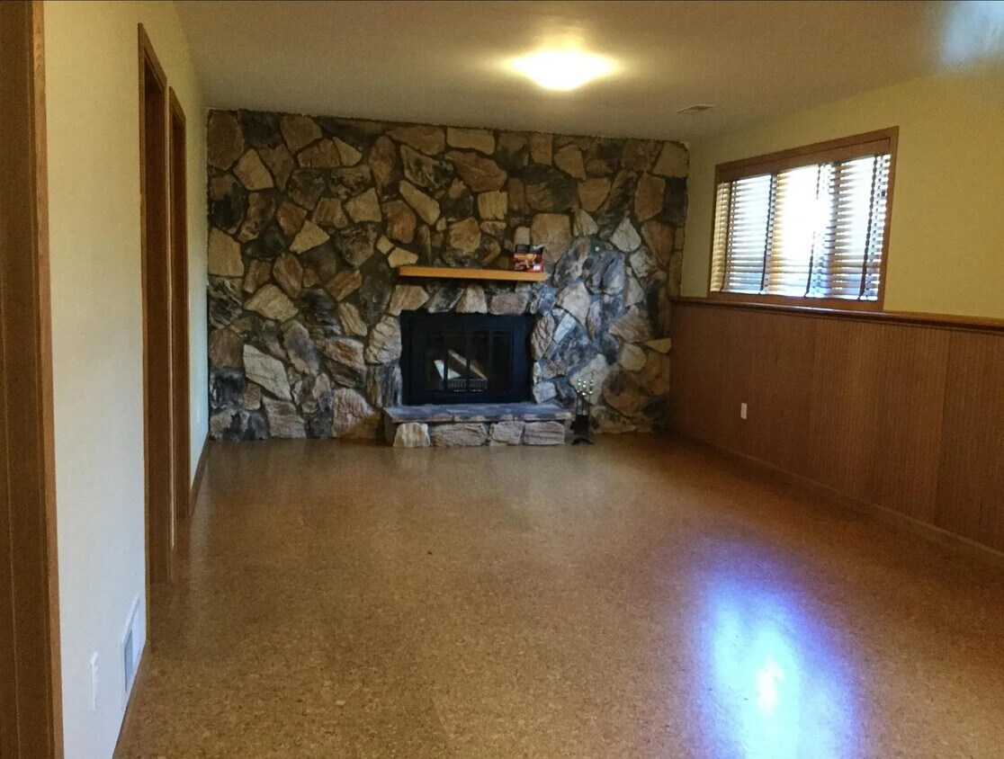 Sala de estar en la planta baja, chimenea de leña, suelo de corcho - 3991 Whiting Ln NE