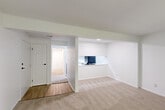 Located at 963 Quail Terrace Ct in Ballwin, MO, this efficiently designed two-bedroom, one-bathroom single-floor home offers a clean, neutral aesthetic throughout. The living room is a comfortable, carpeted space bathed in natural light from a large sliding glass door fitted with vertical blinds, opening to an outdoor view of lush greenery. An open pass-through connects the living area to the galley-style kitchen, which features white cabinetry with black hardware, white countertops, light wood-look flooring, and black appliances including a refrigerator, electric range, and dishwasher. A dedicated laundry area with stacked washer and dryer hookups adds everyday convenience. The primary bedroom is a well-proportioned carpeted retreat with a natural light-filled window and an expansive wall of mirrored sliding closet doors offering generous storage. The second bedroom is equally bright, featuring carpet flooring, a large window with blinds, and its own closet. The full bathroom is finished with clean white tile, a tub-shower combination, a vanity, and warm wood-look flooring. A central hallway connects all rooms seamlessly, completing a practical and cohesive layout.