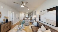 Located at 10800 Colonial Gateway Dr in Fort Myers, FL, this well-appointed one-bedroom, one-bathroom residence offers a thoughtfully designed open-concept layout. The combined kitchen and living area forms the heart of the home, where light wood-tone flooring, neutral walls, and a ceiling fan create a bright, airy atmosphere. The kitchen is a standout feature, showcasing light gray flat-front cabinetry, white quartz countertops, a classic subway tile backsplash, and a full suite of stainless steel appliances including a side-by-side refrigerator, range, built-in microwave, and dishwasher. A peninsula with seating and brushed nickel pendant lighting adds both function and style. The living area provides a comfortable retreat with ample natural light filtering through large windows dressed in sheer curtains and blinds. The bedroom is a serene space, carpeted for comfort, with a ceiling fan and generous window coverage. The walk-in closet offers built-in shelving for organized storage. The bathroom features wood-tone cabinetry, a white quartz vanity top, and a tiled tub/shower combination. Throughout the home, clean lines and modern finishes deliver a cohesive, contemporary living experience.