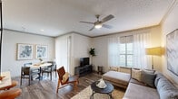 Located at 3700 Preston Rd in Plano, TX, this one-bedroom, one-bathroom residence offers a well-designed single-level layout that makes smart use of its compact footprint. The open-concept living and dining area is anchored by wood-style flooring, crown molding, and a ceiling fan with integrated lighting. Natural light streams in through large windows dressed with sheer curtains and vertical blinds, creating a bright and welcoming atmosphere. The dining space sits adjacent to sliding glass doors, adding an airy feel to the area.

The kitchen is outfitted with white shaker cabinetry, light quartz countertops, a subway tile backsplash, and a full suite of stainless steel appliances including a refrigerator, range, and microwave. A peninsula with a built-in sink provides additional prep space and casual seating.

The bedroom features plush carpeting, a ceiling fan, and a well-sized window that brings in natural light. A dedicated closet and a connecting hallway add to the unit's functional layout. The bathroom includes a tiled tub-shower combo with a curved curtain rod, brushed nickel fixtures, and classic white tile detailing. A hallway provides access to an in-unit washer and dryer, completing this thoughtfully arranged residence.