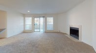 Located at 2 Wyndham Dr in Hampton, Virginia, this single-floor residence offers a practical and comfortable layout with a variety of functional living spaces. The spacious living room serves as the heart of the home, featuring plush wall-to-wall carpeting, a classic fireplace, and large windows alongside a sliding glass door that fills the room with natural light and provides access to an outdoor area. The open flow between the living room and kitchen creates an inviting, connected atmosphere. The kitchen is well-appointed with warm wood cabinetry, dark countertops, hardwood-style flooring, and stainless steel appliances including a dishwasher, range, and built-in microwave. A window above the sink allows for additional natural light. The bedrooms are generously sized, each featuring soft carpeting, ceiling fans with lighting, and windows with blinds. The primary bedroom includes a closet with vertical blinds and direct access to an en-suite bathroom. The bathrooms are cleanly finished — one features hardwood-style flooring, a wood vanity, and a tiled tub-shower combination, while the second offers a similarly functional and tidy design. Overall, the residence presents a clean, neutral palette throughout.