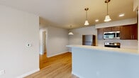 Located at 502 E Fourth Ave in Post Falls, Idaho, this 2-bedroom, 2-bathroom residence offers a thoughtfully designed single-level floor plan with a clean, modern aesthetic. Light-toned walls and warm wood-style flooring run throughout the main living areas, creating a bright and cohesive atmosphere.

The kitchen is a standout feature, equipped with rich dark-stained wood cabinetry, light quartz countertops, stainless steel appliances including a refrigerator, electric range, and microwave, and a stainless undermount sink. Pendant lighting adds a stylish finishing touch above the open dining area, which flows naturally into the living room. A door with sidelight and an adjacent window in the living area welcome natural light and provide outdoor views.

Both bedrooms are carpeted for comfort and include closets for storage. The primary bedroom offers a generous footprint, while the second bedroom is equally functional, with a window overlooking the outdoors. Each bathroom features wood-tone cabinetry, light quartz vanity tops, and hardwood-style flooring. A dedicated in-unit laundry area accommodates a full-size washer and dryer with overhead shelving for added convenience. This residence combines practical layout with contemporary finishes throughout.