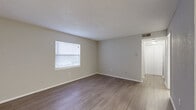 Located at 2175 62nd St N in Clearwater, Florida, this single-floor, 2-bedroom, 2-bathroom residence offers a practical and functional layout across a compact yet well-organized footprint. The living room features wood-look laminate flooring, neutral-toned walls, a textured ceiling, and a window fitted with blinds that allows natural light to filter in. It connects seamlessly to the combined dining and kitchen area, which is a standout feature of the home. The kitchen is outfitted with crisp white shaker-style cabinetry, light countertops, a tile backsplash, and a full suite of stainless steel appliances including a refrigerator, range, microwave, and dishwasher, all set on light wood-look flooring. The primary bedroom is a comfortable size and includes its own closet, while the second bedroom features soft carpeting and a window with natural light. Both bedrooms offer dedicated closet space, with a total of four closets throughout the unit. The two bathrooms are finished in a clean, neutral palette; one includes a tub-shower combination with white tile surround, and the other features a vanity with white cabinetry and a mirror. Additional conveniences include a dedicated laundry area and a central hallway connecting the main spaces.