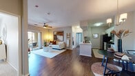 This single-floor residence offers a thoughtfully designed open-concept layout that seamlessly connects the living, dining, and kitchen areas. Rich hardwood-style flooring flows throughout the main living spaces, complemented by neutral wall tones that create a bright, welcoming ambiance. The living room features a ceiling fan, a sliding glass door opening to a private patio, and generous natural light. Adjacent to the living area, a dedicated dining nook provides window views to the outdoors.

The kitchen is well-equipped with white cabinetry, a subway tile backsplash, white countertops, stainless steel appliances including a refrigerator, range, microwave, and dishwasher, and a peninsula with additional prep space. A hallway connects the main living areas to two comfortable bedrooms, each carpeted and fitted with ceiling fans and windows that invite natural light. Both bedrooms include closets, and one features built-in shelving for additional storage.

Two full bathrooms serve the residence, each with white vanity cabinetry, granite-style countertops, a tub-shower combination, and hardwood-style flooring. A dedicated in-unit laundry area provides added everyday convenience, rounding out the functional and cohesive design of this well-planned home.
