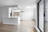 Located on the 14th floor at 125 Wellington St N in Hamilton, Ontario, this 2-bedroom, 1-bathroom unit offers an efficient, well-organized layout across a single floor. Light wood laminate flooring runs throughout the space, lending a clean, cohesive aesthetic to each room.

The kitchen features white cabinetry, light stone-effect countertops, a built-in microwave, and white appliances including a fridge and electric range. It opens directly toward the living area, which benefits from a sliding glass door leading to a private balcony with elevated city views of Hamilton's downtown skyline.

Both bedrooms are bright and simply finished, featuring large windows that frame urban views and baseboard heating. One bedroom includes a built-in sliding-door closet, providing practical storage. Neutral grey-toned walls and light flooring keep both rooms feeling open and airy.

The bathroom is finished with large-format beige tiles lining the tub-shower surround, complemented by chrome fixtures for a clean, functional look.

Two hallways connect the rooms efficiently, and the overall layout makes effective use of the available space. The high-floor positioning enhances natural light and provides commanding views throughout the unit.