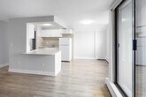 Located on the 14th floor at 125 Wellington St N in Hamilton, Ontario, this 2-bedroom, 1-bathroom unit offers an efficient, well-organized layout across a single floor. Light wood laminate flooring runs throughout the space, lending a clean, cohesive aesthetic to each room.

The kitchen features white cabinetry, light stone-effect countertops, a built-in microwave, and white appliances including a fridge and electric range. It opens directly toward the living area, which benefits from a sliding glass door leading to a private balcony with elevated city views of Hamilton's downtown skyline.

Both bedrooms are bright and simply finished, featuring large windows that frame urban views and baseboard heating. One bedroom includes a built-in sliding-door closet, providing practical storage. Neutral grey-toned walls and light flooring keep both rooms feeling open and airy.

The bathroom is finished with large-format beige tiles lining the tub-shower surround, complemented by chrome fixtures for a clean, functional look.

Two hallways connect the rooms efficiently, and the overall layout makes effective use of the available space. The high-floor positioning enhances natural light and provides commanding views throughout the unit.