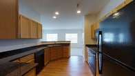 Located at 50 Turnberry Court in Bear, Delaware, this two-story home offers a well-designed layout with functional living spaces across both levels. The kitchen is a standout feature, showcasing warm honey-toned cabinetry, dark granite countertops, and black appliances including a refrigerator, dishwasher, and range. Recessed lighting illuminates the space, complementing the natural light that flows in through multiple windows. The hardwood-style flooring adds warmth and continuity throughout the main level. The kitchen flows naturally toward an open area, creating a connected and spacious feel ideal for everyday living and entertaining. A corner sink with a window view adds a practical yet pleasant touch to the kitchen's layout. The clean white walls and neutral palette provide a versatile backdrop throughout the home. With two floors of living space, this property offers ample room for a variety of lifestyle needs, from comfortable daily living to hosting guests. The overall ambiance is bright, clean, and move-in ready, with a straightforward and functional design that suits a wide range of residents.