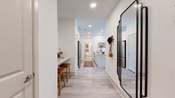 This single-story, 2-bedroom, 2-bathroom residence combines modern design with functional living across a well-organized floor plan. Light-toned luxury vinyl plank flooring flows throughout the main living areas, creating a cohesive and airy feel. The open-concept kitchen and living area serves as the heart of the home, featuring white shaker cabinetry, stainless steel appliances, and a large island with granite countertops and bar seating — ideal for both cooking and casual dining. The living room is brightened by generous windows that invite natural light and is equipped with a ceiling fan for year-round comfort. The primary bedroom offers a comfortable, carpeted retreat with multiple windows, a ceiling fan, and a walk-in closet outfitted with multi-level shelving and hanging rods. The second bedroom features a distinctive two-tone accent wall, adding a bold design touch. Both bathrooms are finished with granite-topped white vanities, tile flooring, and tiled tub-shower combinations. A hallway connecting the bedrooms and bathrooms provides additional storage access via a dedicated closet. Recessed lighting throughout the home ensures consistent illumination, while the clean white walls and neutral palette contribute to a bright, modern ambiance throughout.