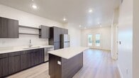 Located at 851 24th St in Ogden, Utah, this thoughtfully designed one-bedroom, one-bathroom unit offers a clean, contemporary aesthetic throughout its efficiently utilized single floor. The open-concept layout seamlessly connects the kitchen, dining, and living areas into one cohesive space, bathed in natural light and anchored by light-toned hardwood-style flooring that runs throughout.

The modern kitchen is a standout feature, boasting dark wood cabinetry, white quartz countertops, a central island with additional seating and storage, and a full suite of stainless steel appliances including a refrigerator, range, microwave, and dishwasher. The living area extends toward a set of elegant French doors that open onto a private balcony, offering outdoor views and abundant natural light.

The bedroom is a comfortable and well-proportioned retreat, featuring a ceiling fan, multiple windows with natural light, and direct access to a dedicated closet and the full bathroom. The bathroom is clean and functional, featuring a full tub-shower combination with built-in shelving. Additional highlights include a utility room, a hallway connecting the private spaces, and recessed lighting throughout, all contributing to a bright and polished modern living environment.