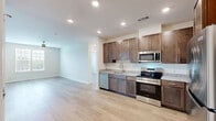 This well-appointed 2-bedroom, 2-bathroom unit at 4824 Walmsley Blvd in Richmond, Virginia offers a thoughtfully designed single-floor layout with a comfortable sense of space throughout. Light-toned wood-style flooring flows consistently across all rooms, creating a clean and cohesive aesthetic.

The kitchen is a standout feature, showcasing rich dark-stained cabinetry with modern hardware, light granite countertops, a tile backsplash, and a full suite of stainless steel appliances including a refrigerator, range, over-the-range microwave, and dishwasher. Recessed lighting illuminates the space effectively.

The living area is bright and airy, with large windows fitted with white horizontal blinds that allow for ample natural light and outdoor views. Both bedrooms are well-sized with neutral walls, ceiling fans, and light-filled windows. The spacious primary bedroom includes its own en-suite bathroom and a dedicated walk-in closet outfitted with wire shelving systems for organized storage.

The bathrooms feature granite-topped vanities with dark wood cabinetry, and the primary bath includes a soaking tub alongside a walk-in closet accessible directly from the bathroom. A second walk-in closet provides additional storage. The overall design is clean, modern, and move-in ready.
