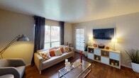 Located at 4715 N Black Canyon Hwy in Phoenix, Arizona, this single-story unit offers a well-organized and functional layout across its living spaces. The living room serves as the heart of the home, featuring durable wood-style flooring, a textured ceiling, and generous natural light streaming through large windows dressed with dark grommet curtains and vertical blinds. A sliding glass door provides direct outdoor access, enhancing the sense of openness. The space comfortably accommodates a full seating arrangement and media setup.

The kitchen is efficiently designed with warm wood-toned cabinetry, light countertops, a tile backsplash, and white appliances including a coil-top range and full-size refrigerator. A ceiling-mounted light fixture illuminates the workspace, making it a practical area for everyday cooking.

The bedroom is a calm, carpeted retreat featuring soft neutral walls, large sliding doors with vertical blinds that invite natural light, and ample room for bedroom furnishings. The layout allows for flexible arrangement and a comfortable living experience.

The bathroom includes a full tub-shower combination with a curtain rod, a standard vanity, and toilet, all finished in clean, neutral tones. Overall, this Phoenix unit presents a cohesive, move-in-ready living environment with warm accents and practical finishes throughout.