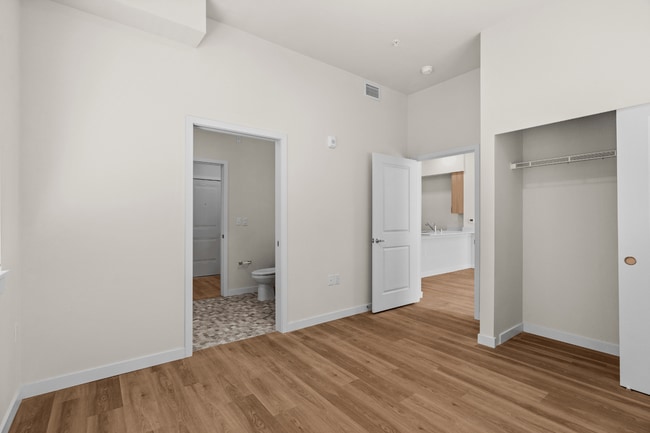 Enjoy a comfortable bedroom retreat with modern finishes, ample closet space, and an attached bathroom for added convenience. - 27 West Apartments