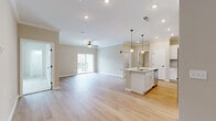 This thoughtfully laid-out 2-bedroom, 2-bathroom residence offers a comfortable and modern living experience on a single floor. The heart of the home is an open-concept kitchen and living area, where light hardwood flooring, crown molding, and recessed lighting create a bright, cohesive atmosphere. A ceiling fan adds functionality to the living space, which opens to an outdoor balcony through a sliding glass door, allowing for natural light and fresh air.

The kitchen is well-appointed with white shaker cabinetry, a subway tile backsplash, granite countertops, and a full suite of stainless steel appliances. A central island with a built-in sink and pendant lighting above serves as both a prep space and a casual gathering spot.

Both bedrooms feature plush carpet flooring and are serviced by two full bathrooms, each finished with white cabinetry, granite vanity tops, and a tub-shower combination. The primary bedroom is generously sized and includes a walk-in closet outfitted with wire shelving systems for organized storage.

A second closet provides additional storage throughout the home. The neutral color palette, clean lines, and consistent finishes throughout give this residence a fresh, move-in-ready feel that is both functional and inviting.