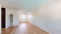 Located at 6363 Beadnell Way in San Diego's Clairemont neighborhood, this one-bedroom, one-bathroom unit offers a well-designed, efficient layout across a single floor. Light wood-style flooring runs throughout the main living areas, complemented by crisp white walls and textured ceilings that create a clean, bright atmosphere.

The open-concept living, dining, and kitchen area forms the heart of the unit. The kitchen is well-appointed with white upper cabinetry, dark lower cabinets, white quartz-style countertops, and stainless steel appliances including a refrigerator, range, and dishwasher. A window over the sink and a ceiling fan above the dining area bring in natural light and airflow. The living room features a second ceiling fan and a front entry door with an adjacent window.

The spacious bedroom is finished with plush carpeting, a wide window allowing natural light, a textured ceiling, and generous closet storage provided by multiple built-in closets with sliding and hinged doors. The full bathroom features a dark wood vanity with a white countertop, a large mirror, and a combined shower-tub with chrome fixtures. Wood-style flooring continues into the bathroom, tying the space together cohesively. A hallway connects the main living areas to the bedroom and bathroom, with additional closet storage accessible along the way.