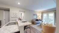 Located at 7405 Long Lake Rd in Columbus, OH, this 4-bedroom, 2-bathroom single-floor residence offers a thoughtfully designed layout with a neutral, contemporary aesthetic throughout. The open-concept kitchen and living area serves as the heart of the home, featuring rich dark cabinetry, light granite-style countertops, black appliances, and a peninsula with bar seating — ideal for casual dining or entertaining. A dedicated closet off the kitchen provides convenient pantry storage. Wood-style flooring extends through the main living areas, transitioning to plush carpet in the living room and bedrooms. The living room is bright and welcoming, with access to a private outdoor area through sliding glass doors fitted with vertical blinds. The four bedrooms offer comfortable, carpeted retreats with warm neutral tones; the primary bedroom includes a closet and natural light from a window. Both bathrooms are well-appointed — one features a walk-in glass shower with a dark vanity and granite countertop, while the second includes a shower-tub combination. A hallway connects the bedroom wing to the main living areas, creating a clear and practical flow throughout the home.