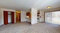 This single-floor residence at Northridge Terrace in Madison, Wisconsin offers a practical and straightforward layout designed for comfortable everyday living. The main living area is generously proportioned, featuring neutral wall-to-wall carpeting and crisp white walls that create a clean, open atmosphere. A sliding glass door floods the space with natural light and provides views of the surrounding greenery outside.

The kitchen is positioned adjacent to the living area, partially separated by a half-wall with a built-in breakfast bar that serves as both a functional workspace and a casual dining spot. The galley-style kitchen features warm wood-toned cabinetry lining both walls, light-colored countertops, white appliances including a range and refrigerator, and easy-to-maintain tile flooring. A dedicated entry door within the kitchen provides convenient access.

The bedrooms are carpeted and offer a calm, neutral environment with wood-trimmed doors consistent with the rest of the unit. The bathroom is finished with light tile flooring, warm wood vanity cabinetry, a white countertop with an integrated sink, and a separate toilet area accessible through an interior door. A hallway connects all rooms, maintaining an efficient and organized flow throughout the single-level floor plan.