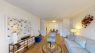 This single-floor residence offers a thoughtfully designed layout with a seamless flow between living, dining, and sleeping spaces. The living room serves as the heart of the home, featuring warm hardwood-style flooring, crisp white walls, and a large sliding glass door that floods the space with natural light and opens directly onto a private outdoor patio. A dedicated dining area sits just off the living room, providing an easy transition for everyday living and entertaining.

The galley kitchen is efficiently organized with white cabinetry, dark countertops, a classic subway tile backsplash, and in-unit washer and dryer. Sleek hardware and ample storage make this kitchen both functional and clean in aesthetic.

The primary bedroom is generously sized, benefiting from multiple windows that invite abundant natural light, with hardwood-style flooring and room for a full furniture arrangement. The second bedroom features a built-in closet with open shelving and hanging space. Both bedrooms are served by their own bathrooms — one full bath with a tub-shower combination finished in white subway tile and marble-look flooring, and a second half bath with a pedestal-style vanity and matching tile flooring. The overall ambiance throughout is light, airy, and move-in ready.