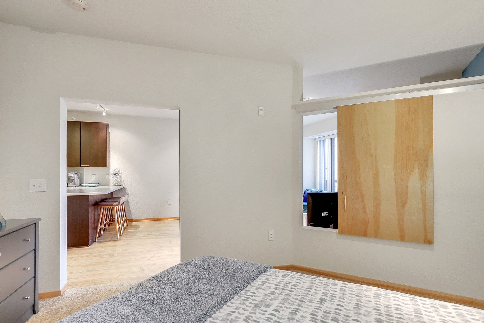 Bedroom with view of kitchen and open sliding barn door.