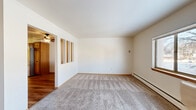This single-floor, 2-bedroom, 1-bathroom unit in Waukesha, Wisconsin offers a practical and comfortable layout with a variety of functional spaces. The entrance leads into a hallway connecting the main living areas, where warm hardwood-style flooring extends throughout the kitchen and common areas, while soft carpet covers the living room and bedrooms.

The kitchen is well-equipped with rich wood cabinetry featuring decorative hardware, white countertops, a double-basin sink, a white electric range, and a stainless steel refrigerator — providing ample storage and workspace for daily use. A cutout pass-through connects the kitchen area to the living room, enhancing the open feel between spaces.

The living room is generously sized, filled with natural light from a large window, and features a ceiling fan and baseboard heating. Both bedrooms are carpeted and offer comfortable proportions, each with natural light from windows and baseboard heating. The spacious primary bedroom provides ample room for furnishings. Four closets distributed throughout the unit offer exceptional storage capacity.

The bathroom includes a full tub/shower combination with light-toned surround, a wood-toned vanity with white countertop, a medicine cabinet with mirror, and hardwood-style flooring — completing this clean, functional, and move-in-ready home.